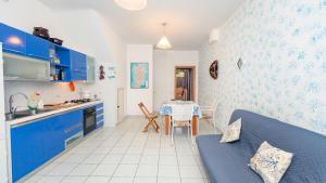 a kitchen and dining room with blue cabinets and a table at Casa Lua in Villasimius