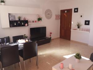 a living room with a table with chairs and a television at TENERIFE HOLIDAY HOME in Candelaria