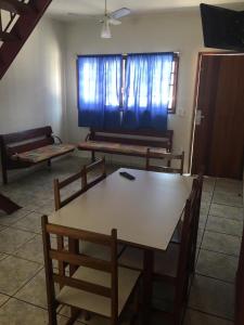 a living room with a table and chairs and a couch at Residencial Albatroz in Caraguatatuba
