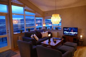 a living room with a couch and a tv at Lax-á Asgardur Cottages in Selfoss