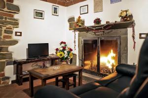 - un salon avec une cheminée, un canapé et une table dans l'établissement Antica dimora figli di Bocco, à Castiglion Fibocchi