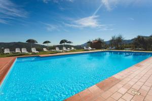 a large blue swimming pool with chairs and umbrellas at Agriturismo Daniela in Bracelli
