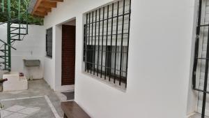 Una pared blanca con ventanas de barrotes negros. en Alojamiento Turistico Mainque, en Las Grutas