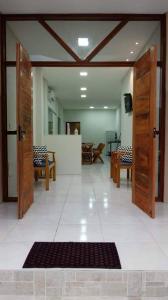 a large room with wooden doors and a rug at Pousada Vô Juca in Gravatal
