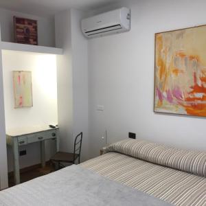 a bedroom with a bed and a desk and a painting at Camere Delle Rose in Milan