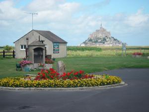 a church with a bunch of flowers in a yard at Vent des Gr&egrave;ves in Pontorson