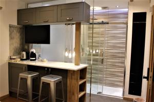 a kitchen with a counter and stools and a shower at RIOSHOUSE Henley in Henley on Thames