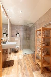 ein Bad mit einem Waschbecken und einer Dusche in der Unterkunft Sonn-Alm Chalet-Apartments in Bichlbach