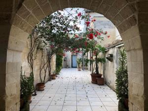 une arche avec des fleurs et des plantes dans une ruelle dans l'établissement Celi Blu Appartamento, à Lizzanello