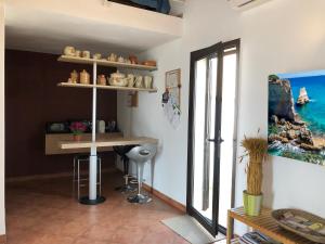 LizzanelloにあるCeli Blu Appartamentoのカウンターとテーブル、窓が備わる客室です。