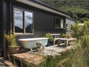 una vasca da bagno seduta su una terrazza di fronte a una casa di The Nook a Arthur's Pass