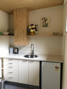 a kitchen with white cabinets and a sink at The Nook in Arthur's Pass