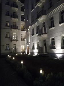 ein großes weißes Gebäude mit Lichtern davor in der Unterkunft Apartment Hoża 50 with a balcony in close Center in Warschau