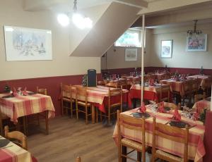 a restaurant with tables with red and yellow tablecloths at Hôtel les Deux Cols in Sainte-Marie-de-Campan
