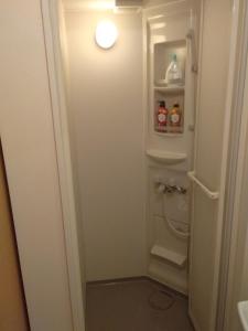 a small bathroom with a toilet and a light at Nice Hostel Kameari in Tokyo