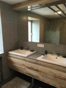 a bathroom with two sinks and a mirror at La Villa Mansard in Kirchheim