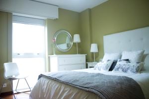 1 dormitorio con 1 cama grande y espejo grande en Apartamento céntrico y tranquilo en Santiago de Compostela, en Santiago de Compostela