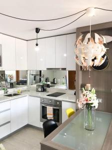 a kitchen with white cabinets and a vase of flowers on a table at Espectacular departamento frente al casino!! in Viña del Mar