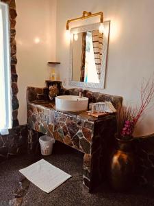 a bathroom with a stone sink and a mirror at White Chocolate Hills Resort in Zamboanguita