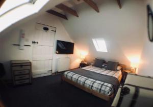 ガーバンにあるAyrshire Holiday Cottageのベッドルーム1室(ベッド1台付)、屋根裏部屋(テレビ付)