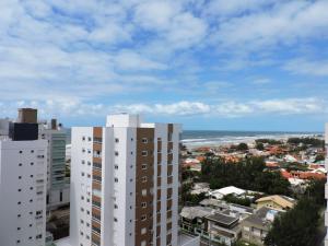 uma vista da cidade e do oceano a partir de um edifício em Excelente Apto Terraço Verde C/Vista Mar Piscina 3 D em Capão da Canoa