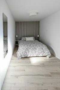 1 dormitorio blanco con 1 cama y suelo de madera en Apartamento turístico en Brunete, en Brunete
