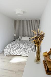 ブルネテにあるApartamento turístico en Bruneteのベッドルーム1室(ベッド1台、テーブル上の花瓶付)