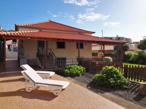 een huis met twee witte stoelen ervoor bij O Cantinho do Zé in Funchal