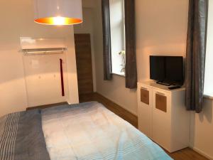 Oberwirt في Lambrechten: غرفة نوم صغيرة بها سرير وتلفزيون