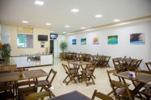 a restaurant with tables and chairs and a counter at Pousada Belezinha in Arraial do Cabo