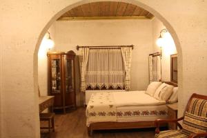 a bedroom with a bed and an arched doorway at Bayer Stone House in Nevşehir