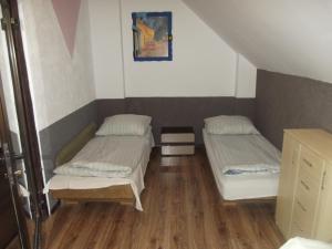 two beds in a small room with wooden floors at Kwatery 42 in Jelenia Góra