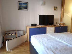 um quarto com uma cama e uma televisão de ecrã plano em Apartment Brinovec em Portorož