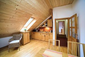 a kitchen with wooden cabinets and a chair in a room at Penzion Mlyn Trestice in Třeštice