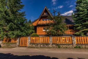 a wooden fence in front of a house at Domek na Stromej in Zakopane