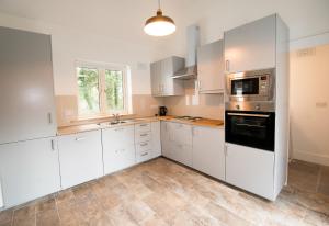 uma cozinha vazia com armários brancos e uma janela em The Wild Farm Cottage em Mullingar
