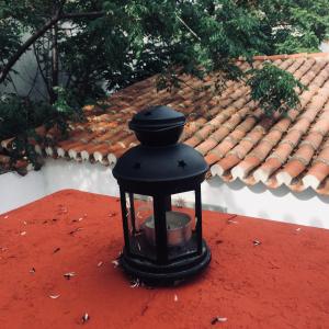 een zwarte lantaarn op een rode muur met een dak bij Traditional Detached House in Spetses