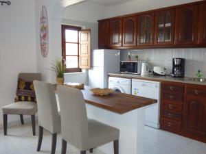 a kitchen with a wooden table and white appliances at Milfontes Paradise in Vila Nova de Milfontes