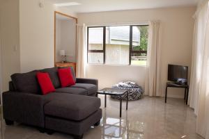 a living room with a couch and a television at Tauhara Luxury Apartment in Okaihau