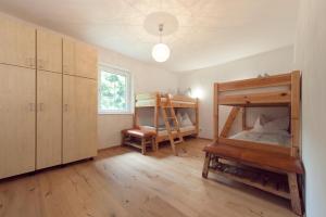 a bedroom with two bunk beds and a chair at Haus am See in Döbriach