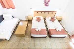 a room with two beds and a table at Lindos Blue Sky in Líndos