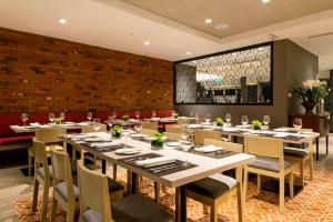 a restaurant with tables and chairs and a brick wall at Mercure Ariosto Lima in Lima