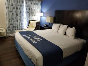 a hotel room with a large bed with a hotel sign on it at Days Inn by Wyndham Thomson in Thomson