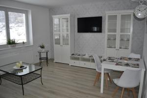 ein Wohnzimmer mit einem weißen Tisch und Stühlen in der Unterkunft Apartmány CENTRUM in Rajecké Teplice