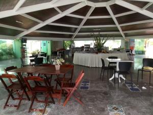 ein Esszimmer mit Tischen und Stühlen sowie einem Tisch mit einem Tisch in der Unterkunft Resort Ancorar Porto de Galinhas Flat 1202 in Porto De Galinhas