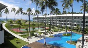 ein Resort mit einem Pool, Palmen und einem Gebäude in der Unterkunft Resort Ancorar Porto de Galinhas Flat 1202 in Porto De Galinhas