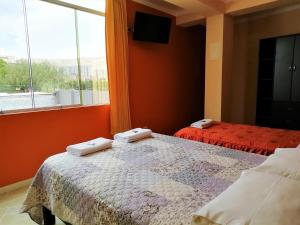 um quarto com 2 camas e uma grande janela em Madison Suite em Tacna