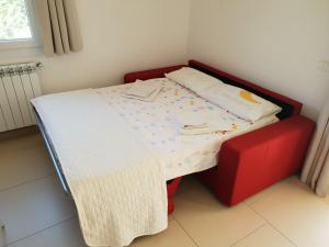 - un petit lit avec une table et une chaise rouge dans l'établissement Villetta Via Lecce, à Galatone