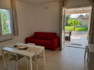ガラトーネにあるVilletta Via Lecceのリビングルーム(赤いソファ、テーブル付)