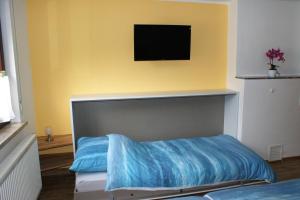 a bedroom with a bed with a blue blanket at Caro's Ferienwohnung in Haard
